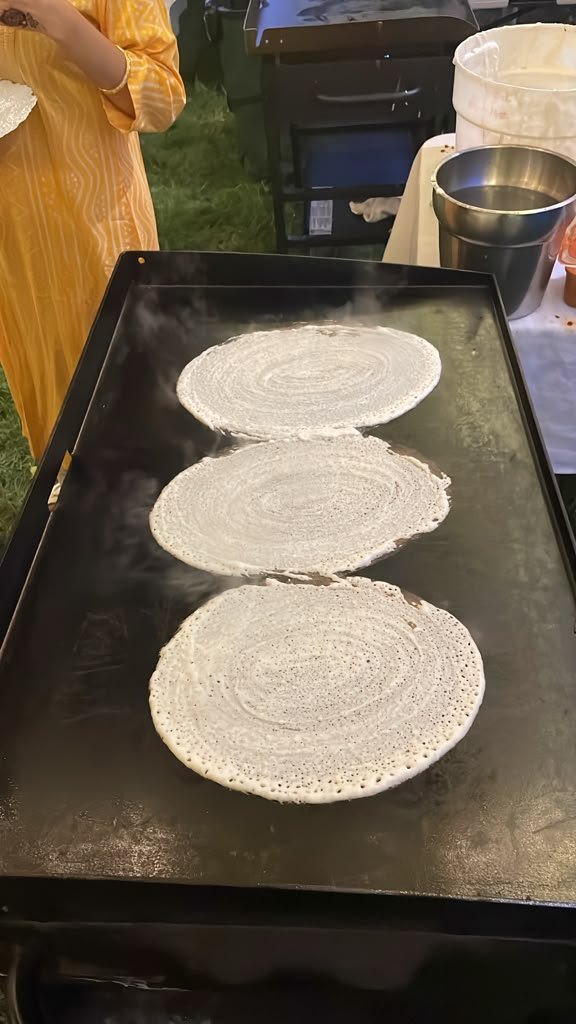 Fresh dosas being cooked to order on a live griddle station